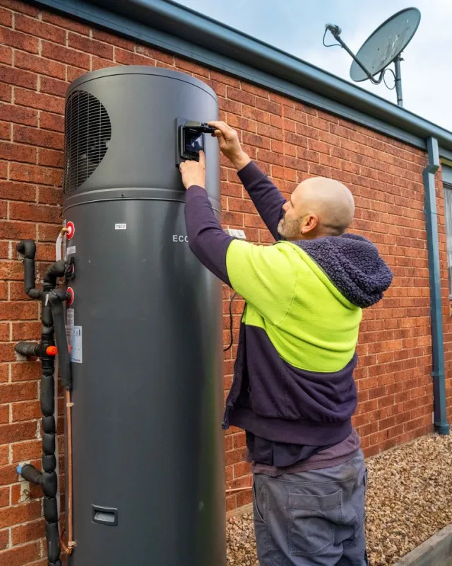 A Goldsure plumber installing a heat pump